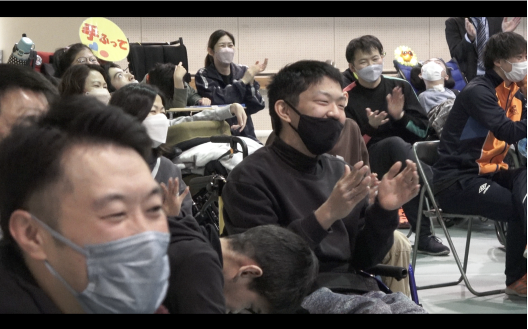 学校訪問イベントで笑顔で拍手する児童・生徒とスタッフ